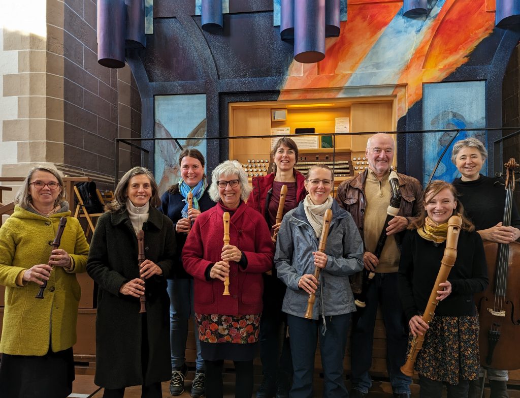 Es sind 8 Musiker:innen mit unterschiedlichen Blockflöten und eine Cellistin vor der Vleugels-Orgel in der Schloßkirche zu sehen.